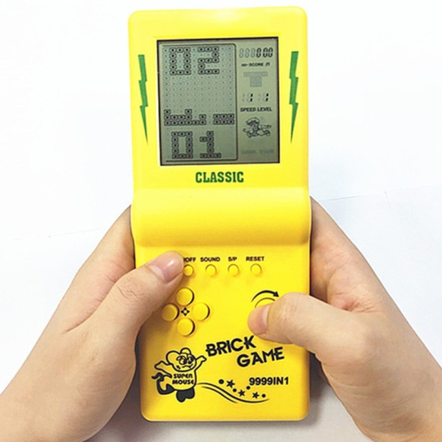 Picture of a retro-style "Brick Game", 9999IN1 game in yellow, with a very bad liquid crystals display.